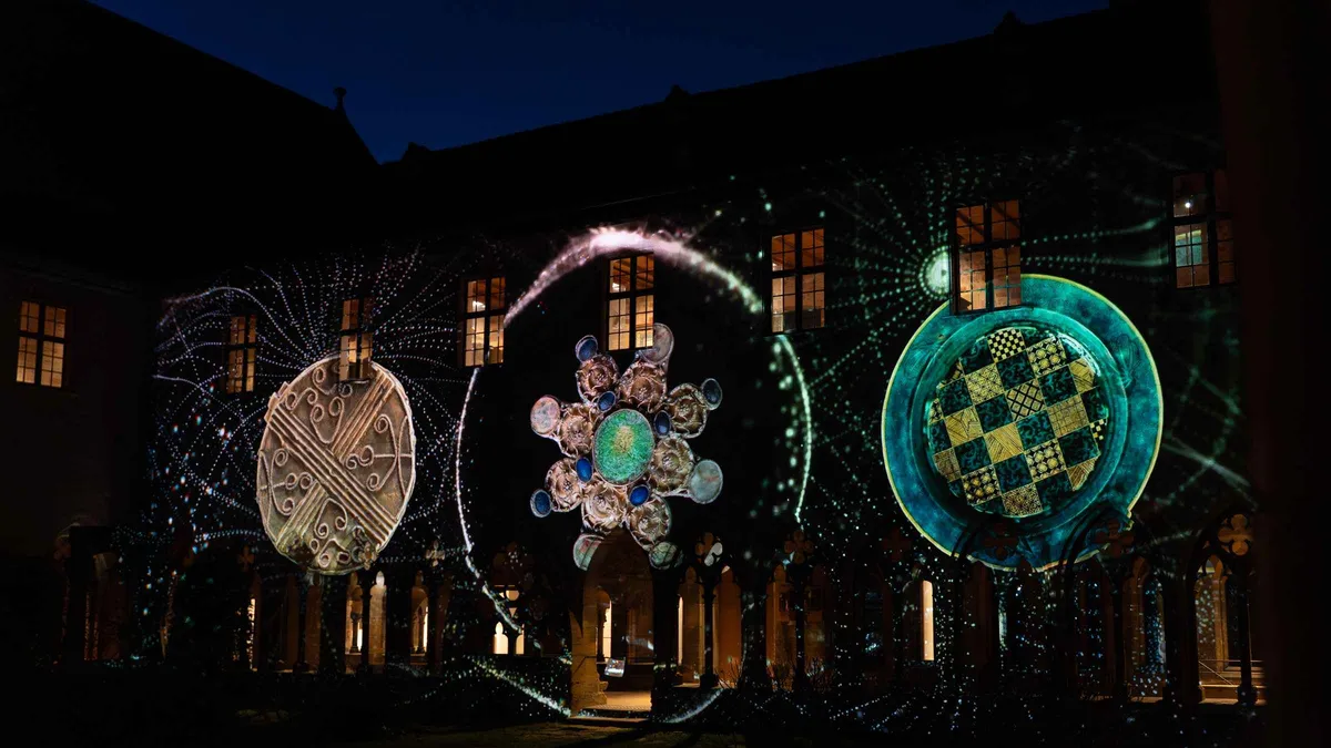 Colored patterns projected on the walls of a cloister at night during a sound-and-light show