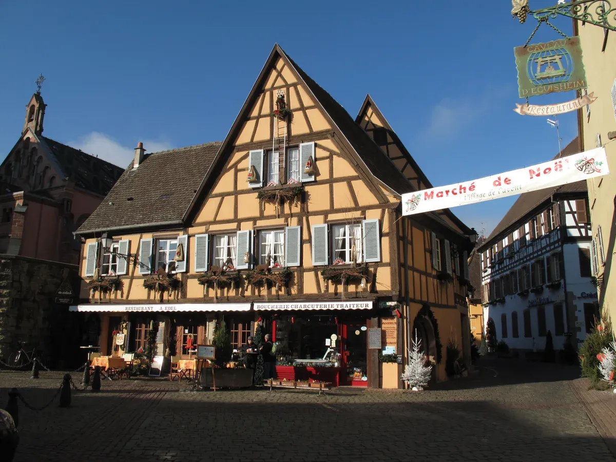 Half-timbered house in Eguisheim hung with a Marché de Noël banner