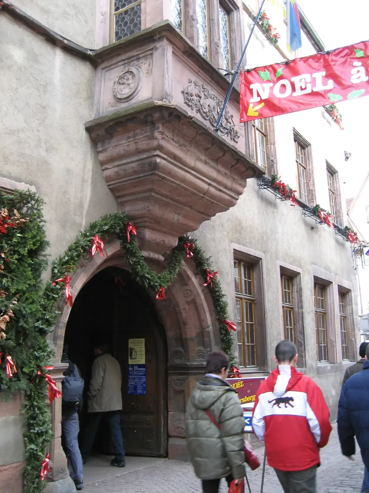 Town hall doorway in Kaysersberg decorated with garlands and a Noël banner